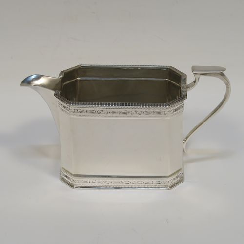 A heavy Sterling Silver three-piece tea set, in a neoclassical style, having plain octagonal bodies with straight sides, applied bead-edged borders above and below bands of bright-cut engraving, with flat-topped scroll side-handles, the teapot with a black wooden scroll handle and a domed lid with bone pineapple finial, and all sitting on flat bases. This beautiful silver three-piece tea set was made by Mappin and Webb of Sheffield in 1926. The dimensions of this fine hand-made silver tea set are length of teapot 26 cms (10.75 inches), height 13.5 cms (5.3 inches), and the total weight is approx. 1,100g (35.5 troy ounces).