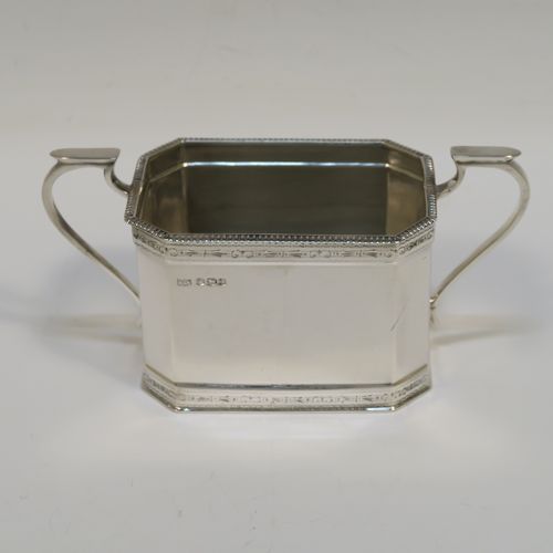 A heavy Sterling Silver three-piece tea set, in a neoclassical style, having plain octagonal bodies with straight sides, applied bead-edged borders above and below bands of bright-cut engraving, with flat-topped scroll side-handles, the teapot with a black wooden scroll handle and a domed lid with bone pineapple finial, and all sitting on flat bases. This beautiful silver three-piece tea set was made by Mappin and Webb of Sheffield in 1926. The dimensions of this fine hand-made silver tea set are length of teapot 26 cms (10.75 inches), height 13.5 cms (5.3 inches), and the total weight is approx. 1,100g (35.5 troy ounces).