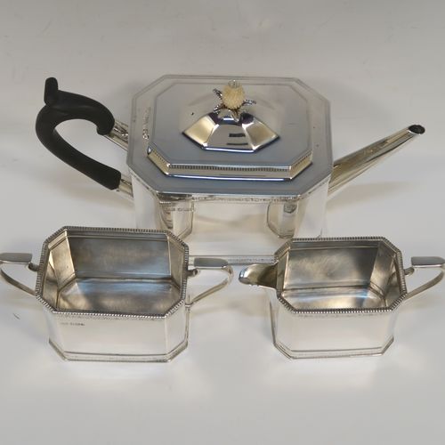 A heavy Sterling Silver three-piece tea set, in a neoclassical style, having plain octagonal bodies with straight sides, applied bead-edged borders above and below bands of bright-cut engraving, with flat-topped scroll side-handles, the teapot with a black wooden scroll handle and a domed lid with bone pineapple finial, and all sitting on flat bases. This beautiful silver three-piece tea set was made by Mappin and Webb of Sheffield in 1926. The dimensions of this fine hand-made silver tea set are length of teapot 26 cms (10.75 inches), height 13.5 cms (5.3 inches), and the total weight is approx. 1,100g (35.5 troy ounces).