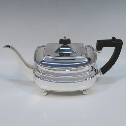 A handsome Antique Edwardian Sterling silver three-piece tea and coffee set, in a Georgian style having plain rectangular bellied bodies and applied gadroon borders, the teapot with invisibly hinged lid, wooden finial and handle, and all sitting on four ball feet. This elegant silver tea set was made by James Dixon and Sons of Sheffield in 1905. The dimensions of this fine hand-made antique silver tea service are length of teapot 29 cms (11.5 inches), height 13.5 cms (5.3 inches), and the total weight is approx. 1,200g (39 troy ounces).