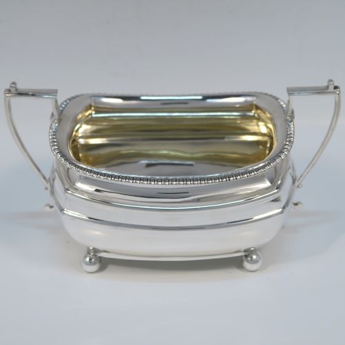 A handsome Antique Edwardian Sterling silver three-piece tea and coffee set, in a Georgian style having plain rectangular bellied bodies and applied gadroon borders, the teapot with invisibly hinged lid, wooden finial and handle, and all sitting on four ball feet. This elegant silver tea set was made by James Dixon and Sons of Sheffield in 1905. The dimensions of this fine hand-made antique silver tea service are length of teapot 29 cms (11.5 inches), height 13.5 cms (5.3 inches), and the total weight is approx. 1,200g (39 troy ounces).