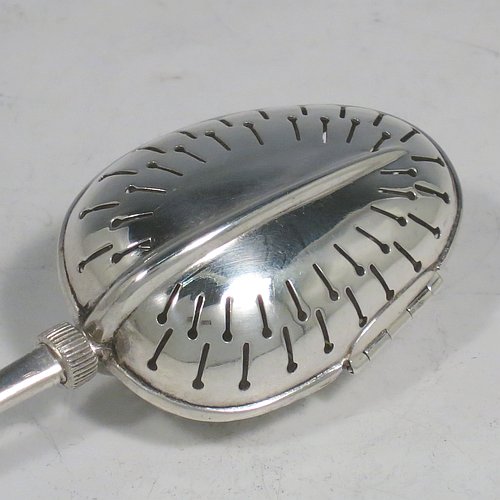 An Antique Victorian Sterling Silver tea infuser spoon, having a hand-pierced oval body, with hinged opening and patented screw-thread closing mechanism, all attached to a plain Old English pattern handle bearing the Teaette patent registration number. Made by George Gray of London in 1894. The dimensions of this fine hand-made antique silver tea infuser spoon are length 14 cms (5.5 inches), and it weighs approx. 47g (1.5 troy ounce).