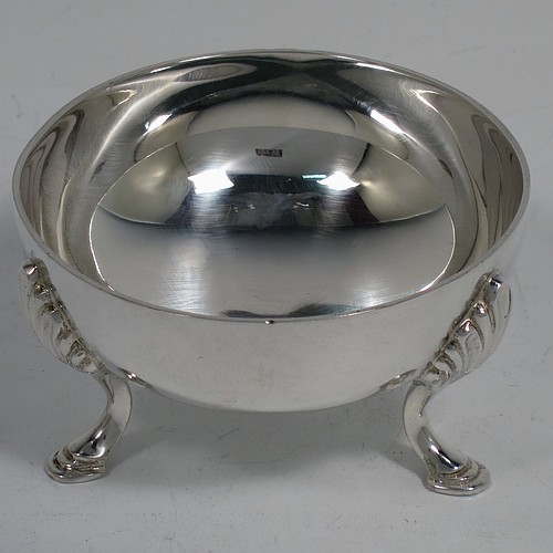 A very handsome, large, and heavy Sterling Silver tea strainer and bowl, having a plain wood-turned handle, a round hand-pierced bowl with an applied reeded border and a cast shell side holder, and sitting on a plain round dregs bowl with three cast hoof feet and shell shoulders. Made by Robert Comyns of London in 1964. The dimensions of this fine hand-made silver tea strainer & bowl are length 19 cms (7.5 inches), diameter of bowl 8 cms (3 inches), with a total weight of approx. 155g (5 troy ounces).