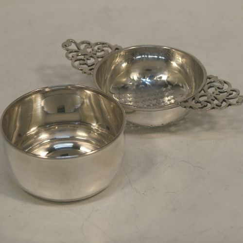 A handsome Sterling Silver tea strainer and dregs bowl in a Georgian lemon strainer style, having a round hand-pierced bowl, with two hand-pierced side-handles, and sitting on an original plain round dregs stand with a flat base. Made by Mappin and Webb of Birmingham in 1930. The dimensions of this fine hand-made silver tea strainer and bowl are height 4 cms (1.5 inches), width across handles 12 cms (4.75 inches), and it weighs a total of approx. 86g (2.8 troy ounces).  