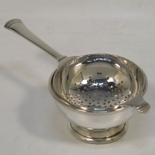 A handsome Art Deco style Sterling Silver tea strainer and bowl, having a round hand-pierced strainer with reeded borders, and sitting on its original plain round bowl on a pedestal foot. This elegant silver tea strainer and bowl was made by Edward Barnard of London in 1955. The dimensions of this fine hand-made silver tea strainer and bowl are length 14 cms (5.5 inches), diameter of bowl 6.5 cms (2.6 inches), and with a total weight of approx. 100g (3.2 troy ounces).  