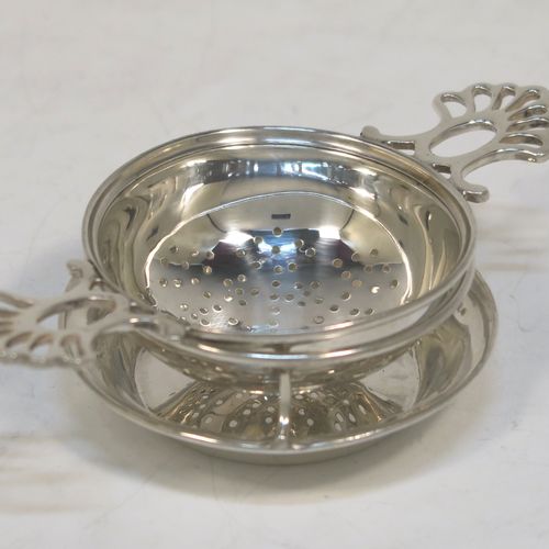 A very stylish Antique Sterling Silver tea strainer and stand, having a round hand-pierced bowl with two pierced side-handles, all sitting on an original plain round dregs stand with a wire-work galleried holder on a flat base. This elegant antique silver tea strainer and stand was made by Thomas Bradbury and Sons of Sheffield in 1918 / 1919. The dimensions of this fine hand-made antique silver tea strainer and stand are height 3 cms (1.25 inches), length over handles 11.5 cms (4.5 inches), and it weighs a total of approx. 44g (1.4 troy ounces).  
