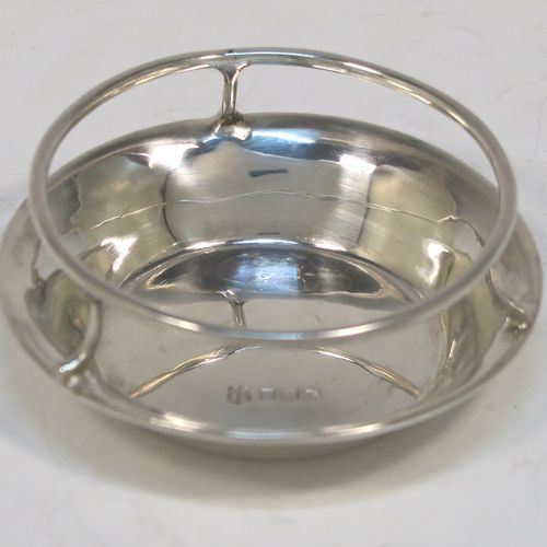 A very stylish Antique Sterling Silver tea strainer and stand, having a round hand-pierced bowl with two pierced side-handles, all sitting on an original plain round dregs stand with a wire-work galleried holder on a flat base. This elegant antique silver tea strainer and stand was made by Thomas Bradbury and Sons of Sheffield in 1918 / 1919. The dimensions of this fine hand-made antique silver tea strainer and stand are height 3 cms (1.25 inches), length over handles 11.5 cms (4.5 inches), and it weighs a total of approx. 44g (1.4 troy ounces).