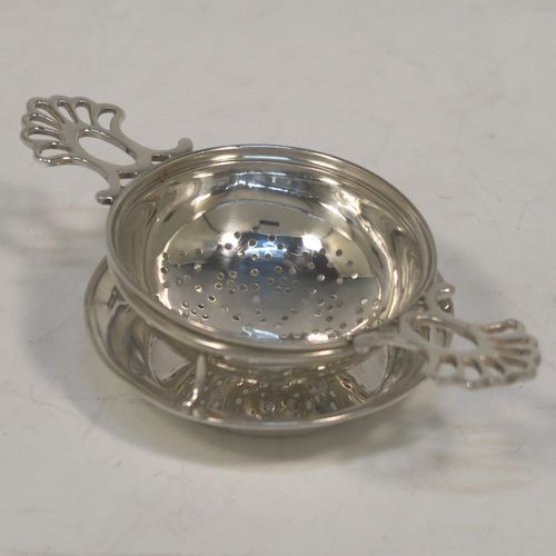A very stylish Antique Sterling Silver tea strainer and stand, having a round hand-pierced bowl with two pierced side-handles, all sitting on an original plain round dregs stand with a wire-work galleried holder on a flat base. This elegant antique silver tea strainer and stand was made by Thomas Bradbury and Sons of Sheffield in 1918 / 1919. The dimensions of this fine hand-made antique silver tea strainer and stand are height 3 cms (1.25 inches), length over handles 11.5 cms (4.5 inches), and it weighs a total of approx. 44g (1.4 troy ounces).