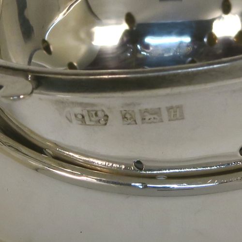 A handsome Sterling Silver tea strainer and dregs bowl, having a round hand-pierced bowl, with two hand-pierced side-handles, and sitting on an original plain round dregs stand. This elegant silver tea strainer and bowl was made by Larson Ltd. of Birmingham in 1957. The dimensions of this fine hand-made silver tea strainer and dregs stand are height 3 cms (1.25 inches), diameter of dregs stand 8 cms (3.25 inches), and it weighs a total of approx. 63g (2 troy ounces).   
