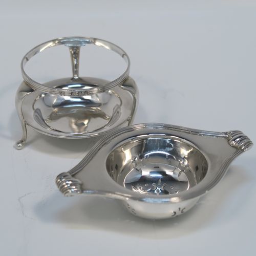 A very stylish Antique Sterling Silver tea strainer and stand, having a round hand-pierced bowl with an applied reeded border and side-handles, all sitting on an original plain round dregs stand with a wire-work galleried holder  with three cabriolet legs. This elegant silver tea strainer and stand was made by Robert Pringle of London in 1928. The dimensions of this fine hand-made silver tea strainer and stand are height 4 cms (1.5 inches), length over handles 10 cms (4 inches), and it weighs a total of approx. 77g (2.5 troy ounces).   