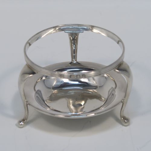 A very stylish Antique Sterling Silver tea strainer and stand, having a round hand-pierced bowl with an applied reeded border and side-handles, all sitting on an original plain round dregs stand with a wire-work galleried holder  with three cabriolet legs. This elegant silver tea strainer and stand was made by Robert Pringle of London in 1928. The dimensions of this fine hand-made silver tea strainer and stand are height 4 cms (1.5 inches), length over handles 10 cms (4 inches), and it weighs a total of approx. 77g (2.5 troy ounces).   