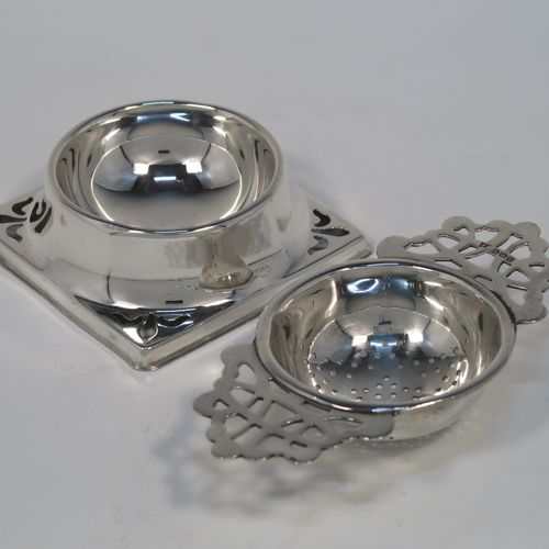 A handsome Sterling Silver tea strainer and dregs bowl, having a Georgian lemon strainer style round hand-pierced bowl, with two hand-pierced side-handles, and sitting on an original plain round dregs stand with a square base. This elegant silver tea strainer and bowl was made by Thomas Bishton of Birmingham in 1944. The dimensions of this fine hand-made silver tea strainer and dregs stand are height 2.5 cms (1 inch), length of strainer 11.5 cms (4.25 inches), and the dregs stand is 7.5 cms (3 inches) square inches), and it weighs a total of approx. 68g (2.2 troy ounces).