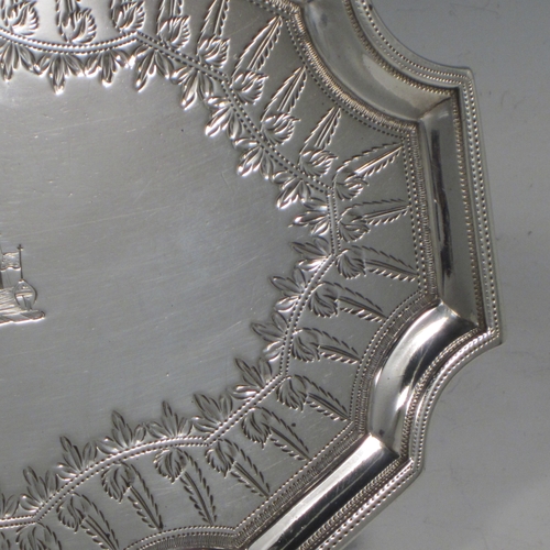 Antique Georgian sterling silver Neoclassical style teapot stand having a shaped rectangular body with a raised border, a hand-engraved ground with floral decoration, and sitting on four flange feet. Made by Henry Chawner of London in 1789. The dimensions of this fine hand-made silver teapot stand are length 16.5 cms (6.5 inches), width 12.5 cms (5 inches), and it weighs approx. 140g (4.5 troy ounces). Please note that this item is crested.