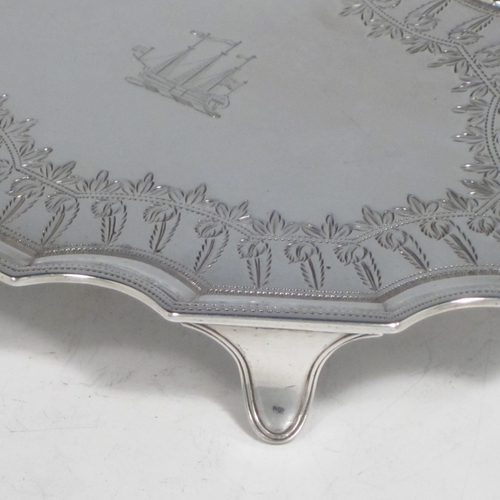Antique Georgian sterling silver Neoclassical style teapot stand having a shaped rectangular body with a raised border, a hand-engraved ground with floral decoration, and sitting on four flange feet. Made by Henry Chawner of London in 1789. The dimensions of this fine hand-made silver teapot stand are length 16.5 cms (6.5 inches), width 12.5 cms (5 inches), and it weighs approx. 140g (4.5 troy ounces). Please note that this item is crested.