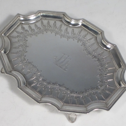 Antique Georgian sterling silver Neoclassical style teapot stand having a shaped rectangular body with a raised border, a hand-engraved ground with floral decoration, and sitting on four flange feet. Made by Henry Chawner of London in 1789. The dimensions of this fine hand-made silver teapot stand are length 16.5 cms (6.5 inches), width 12.5 cms (5 inches), and it weighs approx. 140g (4.5 troy ounces). Please note that this item is crested.