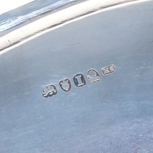 A very pretty Antique Georgian Sterling Silver teapot stand, having a rectangular body with rounded corners and a band of bright-cut hand-engraved floral decoration, a raised border with an applied reeded edge, and sitting on four ball feet. This elegant antique silver teapot stand was made by Soloman Hougham of London in 1804. The dimensions of this fine hand-made antique silver teapot stand are length 16 cms (6.3 inches), width 12.5 cms (5 inches), and it weighs approx. 153g (4.9 troy ounces).