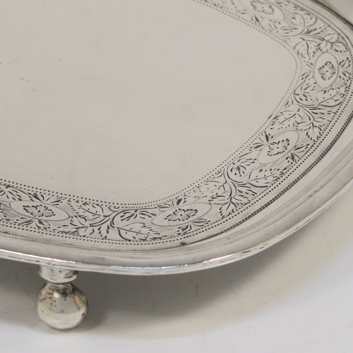 A very pretty Antique Georgian Sterling Silver teapot stand, having a rectangular body with rounded corners and a band of bright-cut hand-engraved floral decoration, a raised border with an applied reeded edge, and sitting on four ball feet. This elegant antique silver teapot stand was made by Soloman Hougham of London in 1804. The dimensions of this fine hand-made antique silver teapot stand are length 16 cms (6.3 inches), width 12.5 cms (5 inches), and it weighs approx. 153g (4.9 troy ounces).
