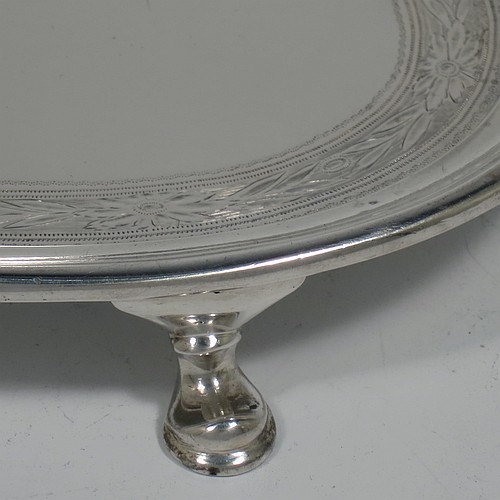 A very handsome Antique Edwardian Sterling Silver teapot stand, having an oval body with a band of hand-engraved floral decoration, a raised border with an applied reeded edge, and sitting on four cast hoof feet. Made by the Pairpoint Brothers of London in 1905. The dimensions of this fine hand-made antique silver teapot stand are length 17.5 cms (7 inches), width 13 cms (5 inches), and it weighs approx. 238g (7.8 troy ounces).