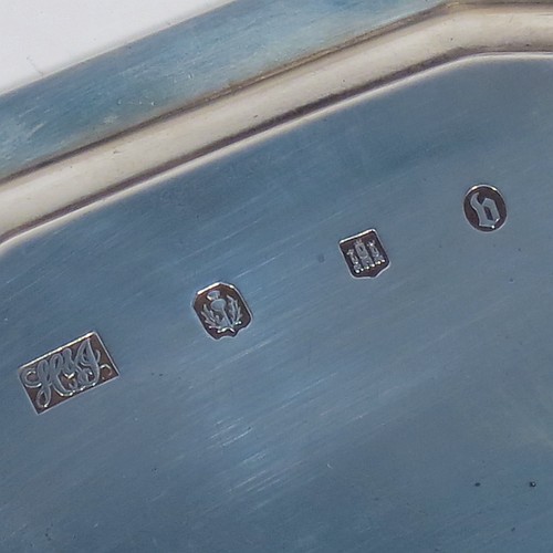 An Antique Victorian Scottish Sterling Silver teapot stand, having a shaped and cut-cornered oval body with an applied reeded border, the flat ground with a hand-engraved beaded band surrounding a central vacant cartouche, and all sitting on four flange feet. Made by Hamilton & Inches of Edinburgh in 1883. The dimensions of this fine hand-made antique silver teapot stand are length 18 cms (7 inches), width 13 cms (5 inches), and it weighs approx. 150g (4.8 troy ounces).