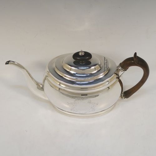 A very handsome Antique Georgian Sterling Silver teapot, having a plain oval body with curved sides and reeded decoration, with engraved vacant cartouches on both sides, a curved tapering spout, a wooden scroll handle and finial, an invisibly hinged domed lid, and all sitting on a flat base. This elegant Georgian silver teapot was made by Soloman Hougham of London in 1800. The dimensions of this fine hand-made antique silver teapot are length 28 cms (11 inches), height 16 cms (6.3 inches), and it weighs approx. 450g (14.5 troy ounces).  