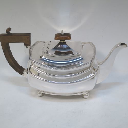 A very handsome Sterling Silver teapot, having a rectangular bellied body with two hand-chased girdle bands and an applied upper gadroon border, a brown wooden handle with thumb-piece, a domed lid with wooden finial, a plain square cross-section spout, and all sitting on four ball feet. Made by S. Blankensee and Sons of Chester in 1933. The dimensions of this fine hand-made silver teapot are length 27 cms (10.5 inches), width 13 cms (5 inches), height 15 cms (6 inches), and it weighs approx. 698g (22.5 troy ounces).   