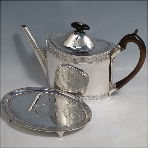 An Antique Georgian Sterling Silver teapot on stand, having a hand-engraved oval body, with bands of floral decoration, a hinged domed lid with wooden finial and flat hidden hinge, a wooden scroll handle, and sitting on a matching stand with four flanged feet and reeded border. The teapot made by Frances Purton of London in 1794, and the stand by Timothy Renou of London in 1795. The dimensions of this fine hand-made antique silver teapot on stand are length 26 cms (10.25 inches), height (on stand) 16 cms (6.25 inches), and it weighs approx. 475g (15.2 troy ounces).