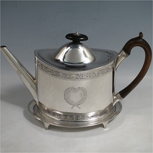 An Antique Georgian Sterling Silver teapot on stand, having a hand-engraved oval body, with bands of floral decoration, a hinged domed lid with wooden finial and flat hidden hinge, a wooden scroll handle, and sitting on a matching stand with four flanged feet and reeded border. The teapot made by Frances Purton of London in 1794, and the stand by Timothy Renou of London in 1795. The dimensions of this fine hand-made antique silver teapot on stand are length 26 cms (10.25 inches), height (on stand) 16 cms (6.25 inches), and it weighs approx. 475g (15.2 troy ounces).