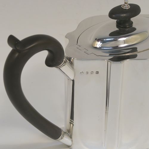 A very handsome Neoclassical style Antique Sterling Silver teapot, having a plain shaped oval straight-sided body, a straight tapering spout, a wooden scroll handle and oval finial, an invisibly hinged domed lid, and all sitting on a flat base. This elegant antique silver teapot was made by Thomas Wooley of Birmingham in 1914. The dimensions of this fine hand-made antique silver teapot are length 27 cms (10.5 inches), height 14 cms (5.5 inches), and it weighs approx. 495g (16 troy ounces).