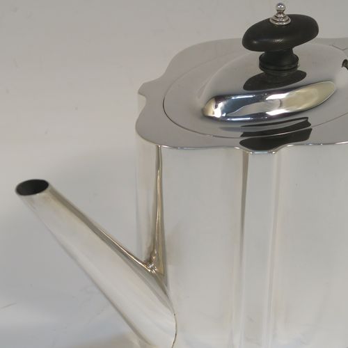 A very handsome Neoclassical style Antique Sterling Silver teapot, having a plain shaped oval straight-sided body, a straight tapering spout, a wooden scroll handle and oval finial, an invisibly hinged domed lid, and all sitting on a flat base. This elegant antique silver teapot was made by Thomas Wooley of Birmingham in 1914. The dimensions of this fine hand-made antique silver teapot are length 27 cms (10.5 inches), height 14 cms (5.5 inches), and it weighs approx. 495g (16 troy ounces).