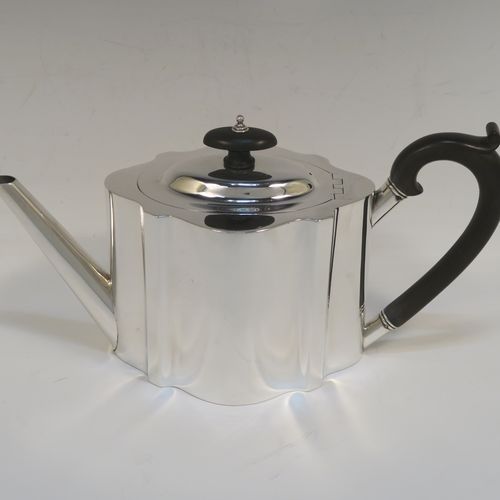 A very handsome Neoclassical style Antique Sterling Silver teapot, having a plain shaped oval straight-sided body, a straight tapering spout, a wooden scroll handle and oval finial, an invisibly hinged domed lid, and all sitting on a flat base. This elegant antique silver teapot was made by Thomas Wooley of Birmingham in 1914. The dimensions of this fine hand-made antique silver teapot are length 27 cms (10.5 inches), height 14 cms (5.5 inches), and it weighs approx. 495g (16 troy ounces).