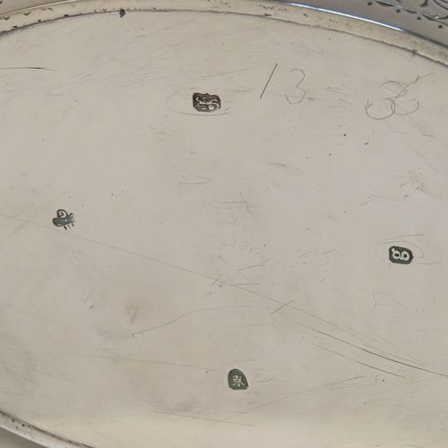 A very elegant Neoclassical style Antique Georgian Sterling Silver teapot, having an oval straight-sided body with hand-engraved upper and lower bands of floral work, with an oval engraved cartouche on one side, a straight tapering spout, a wooden scroll handle and oval finial, an invisibly hinged flat lid with matching engraving, and all sitting on a flat base. This beautiful antique silver teapot was made by Charles Aldridge and Henry Green of London in 1782. The dimensions of this fine hand-made antique silver teapot are length 26 cms (10.25 inches), height 11.5 cms (4.5 inches), and it weighs approx. 375g (12 troy ounces).