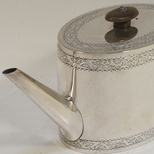 A very elegant Neoclassical style Antique Georgian Sterling Silver teapot, having an oval straight-sided body with hand-engraved upper and lower bands of floral work, with an oval engraved cartouche on one side, a straight tapering spout, a wooden scroll handle and oval finial, an invisibly hinged flat lid with matching engraving, and all sitting on a flat base. This beautiful antique silver teapot was made by Charles Aldridge and Henry Green of London in 1782. The dimensions of this fine hand-made antique silver teapot are length 26 cms (10.25 inches), height 11.5 cms (4.5 inches), and it weighs approx. 375g (12 troy ounces).