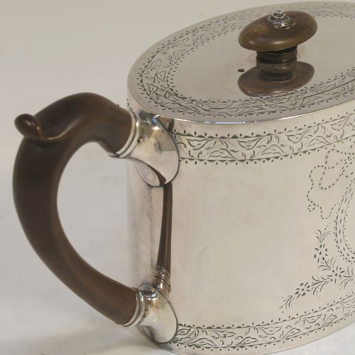 A very elegant Neoclassical style Antique Georgian Sterling Silver teapot, having an oval straight-sided body with hand-engraved upper and lower bands of floral work, with an oval engraved cartouche on one side, a straight tapering spout, a wooden scroll handle and oval finial, an invisibly hinged flat lid with matching engraving, and all sitting on a flat base. This beautiful antique silver teapot was made by Charles Aldridge and Henry Green of London in 1782. The dimensions of this fine hand-made antique silver teapot are length 26 cms (10.25 inches), height 11.5 cms (4.5 inches), and it weighs approx. 375g (12 troy ounces).