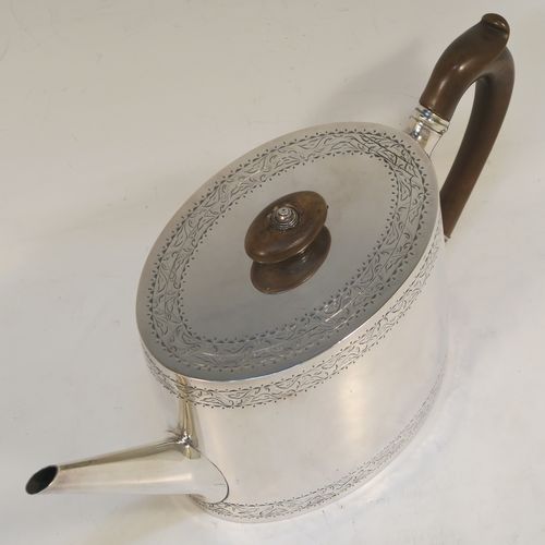 A very elegant Neoclassical style Antique Georgian Sterling Silver teapot, having an oval straight-sided body with hand-engraved upper and lower bands of floral work, with an oval engraved cartouche on one side, a straight tapering spout, a wooden scroll handle and oval finial, an invisibly hinged flat lid with matching engraving, and all sitting on a flat base. This beautiful antique silver teapot was made by Charles Aldridge and Henry Green of London in 1782. The dimensions of this fine hand-made antique silver teapot are length 26 cms (10.25 inches), height 11.5 cms (4.5 inches), and it weighs approx. 375g (12 troy ounces).