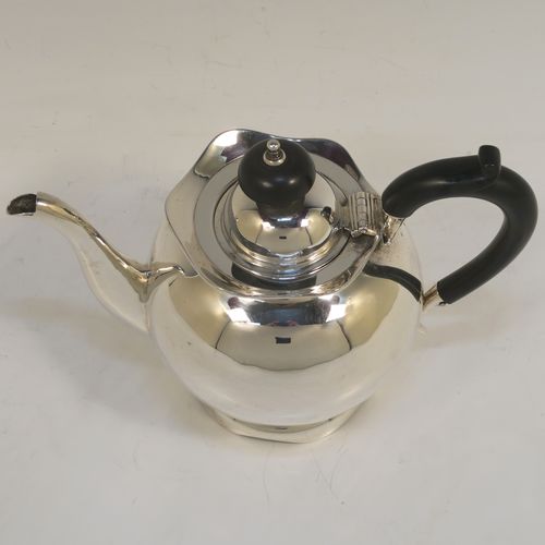 A small and pretty Antique Edwardian Sterling Silver bachelor size teapot, having a plain round bellied body, a wooden insulated handle, a hinged domed lid and wooden finial, and all sitting on a pedestal foot. This elegant antique silver teapot was made by Williams Ltd., of Birmingham in 1907. The dimensions of this fine hand-made silver bachelor teapot are height 12.5 cms (5 inches), length 17.5 cms (7 inches), and it weighs is approx. 250g (8 troy ounces).