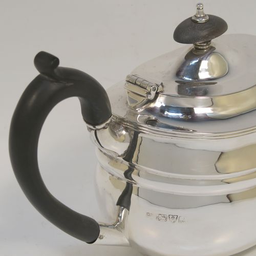 A very handsome Antique Sterling Silver teapot, having a plain oval body with curved sides and reeded decoration, a curved tapering spout, a wooden scroll handle and finial, a hinged domed lid, and all sitting on a flat base. This elegant silver teapot was made by Nathan and Hayes of Chester in 1912. The dimensions of this fine hand-made antique silver teapot are length 23 cms (9 inches), height 12.5 cms (5 inches), and it weighs approx. 350g (11.3 troy ounces).
