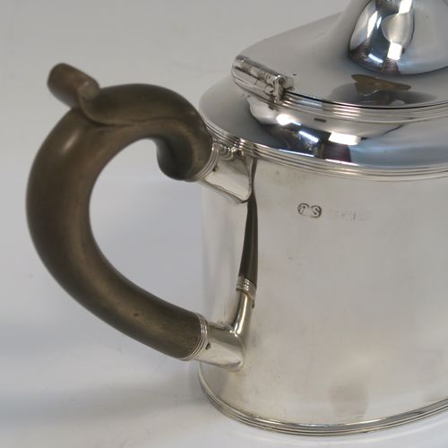 A very handsome Neoclassical style Antique Sterling Silver teapot, having a very plain oval straight-sided body with applied reeded borders, a straight tapering spout, a wooden scroll handle, a hinged domed lid with an oval wooden finial, and all sitting on a flat base. This very elegant antique silver teapot was made by Robert Stewart of Birmingham in 1922. The dimensions of this fine hand-made antique silver teapot are length 27 cms (10.5 inches), height 14 cms (5.5 inches), and it weighs approx. 450g (14.5 troy ounces).