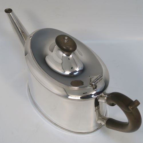 A very handsome Neoclassical style Antique Sterling Silver teapot, having a very plain oval straight-sided body with applied reeded borders, a straight tapering spout, a wooden scroll handle, a hinged domed lid with an oval wooden finial, and all sitting on a flat base. This very elegant antique silver teapot was made by Robert Stewart of Birmingham in 1922. The dimensions of this fine hand-made antique silver teapot are length 27 cms (10.5 inches), height 14 cms (5.5 inches), and it weighs approx. 450g (14.5 troy ounces).