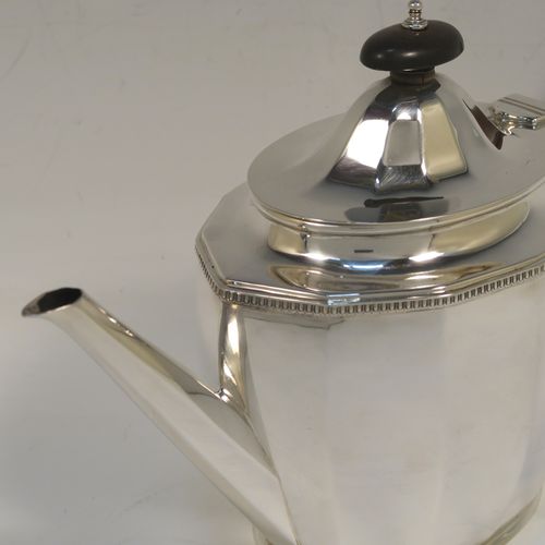 A very handsome Sterling Silver teapot, having a plain oval body with paneled curved sides and an applied gadroon border, a straight tapering spout, a wooden scroll handle and finial, and all sitting on a flat base. This elegant silver teapot was made by Alexander Clarke of Birmingham in 1932. The dimensions of this fine hand-made silver teapot are length 28 cms (11 inches), height 16.5 cms (6.5 inches), and it weighs approx. 530g (17 troy ounces).