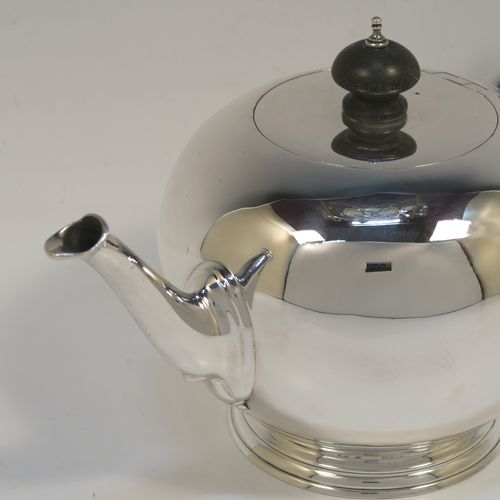 A very handsome Antique Sterling Silver teapot in an early George II Bullet or Skittle Ball style, having a very plain round bellied body, a straight tapering spout, a wooden scroll handle and finial, an invisibly hinged flat lid, and sitting on a pedestal foot. This elegant antique silver teapot was made by Charles Stuart Harris of London in 1919. The dimensions of this fine hand-made silver skittle ball style teapot are length 25.5 cms (10 inches), height 13 cms (5 inches), and it weighs approx. 500g (16 troy ounces).