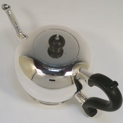 A very handsome Antique Sterling Silver teapot in an early George II Bullet or Skittle Ball style, having a very plain round bellied body, a straight tapering spout, a wooden scroll handle and finial, an invisibly hinged flat lid, and sitting on a pedestal foot. This elegant antique silver teapot was made by Charles Stuart Harris of London in 1919. The dimensions of this fine hand-made silver skittle ball style teapot are length 25.5 cms (10 inches), height 13 cms (5 inches), and it weighs approx. 500g (16 troy ounces).