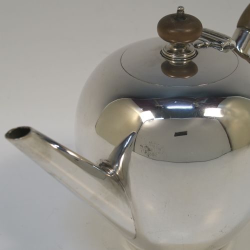 A very handsome Antique Sterling Silver teapot in an early George II Bullet or Skittle Ball style, having a very plain round bellied body, a straight tapering spout, a wooden scroll handle and finial, a hinged flat lid, and sitting on a collet foot. This elegant silver teapot was made by Alexander Osborne London in 1917. The dimensions of this fine hand-made silver skittle ball style teapot are length 23 cms (9 inches), height 12.5 cms 5 inches), and it weighs approx. 340g 11 troy ounces).