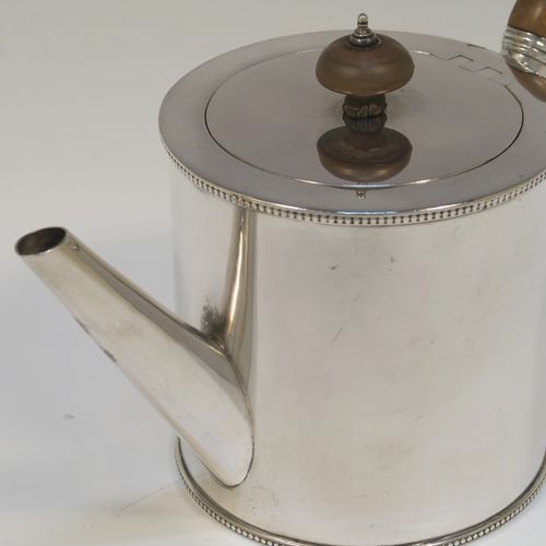 A very handsome Neoclassical style Antique Georgian Sterling Silver Saffron teapot in a very plain round straight-sided body, with applied bead-edged borders, a straight tapering spout, a wooden scroll handle and round finial, an invisibly hinged flat lid, and all sitting on a flat base. This beautiful antique silver saffron teapot was made by Walter Brind of London in 1774. The dimensions of this fine hand-made antique silver teapot are length 22 cms (8.75 inches), height 13.5 cms (5.3 inches), and it weighs approx. 450g (14.5 troy ounces).