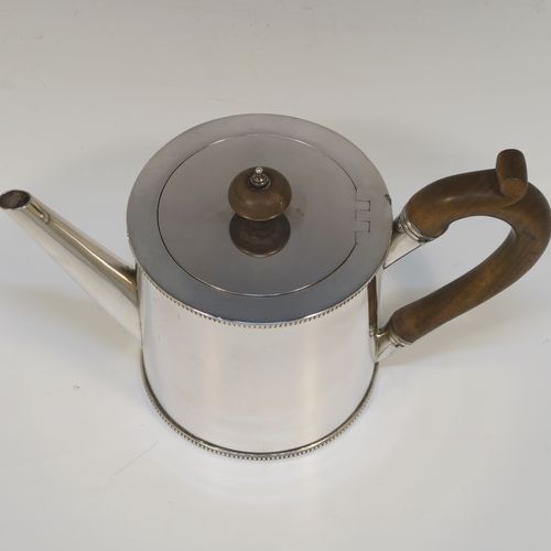 A very handsome Neoclassical style Antique Georgian Sterling Silver Saffron teapot in a very plain round straight-sided body, with applied bead-edged borders, a straight tapering spout, a wooden scroll handle and round finial, an invisibly hinged flat lid, and all sitting on a flat base. This beautiful antique silver saffron teapot was made by Walter Brind of London in 1774. The dimensions of this fine hand-made antique silver teapot are length 22 cms (8.75 inches), height 13.5 cms (5.3 inches), and it weighs approx. 450g (14.5 troy ounces).