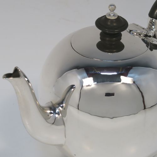 A small but beautifully made Antique Victorian Sterling Silver teapot in an early George II Bullet or Skittle Ball style, having a very plain round bellied body, a curved spout, a wooden scroll handle and finial, a hinged flat lid, and sitting flat base. This elegant silver bachelor sized teapot was made by Wakely and Wheeler of London in 1897. The dimensions of this fine hand-made silver skittle ball style teapot are length 17 cms (6.75 inches), height 11.5 cms (4.5 inches), and it weighs approx. 200g (6.5 troy ounces).