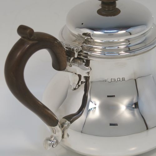 A very handsome Sterling Silver Bachelor size teapot, in a George I style with a plain round bellied body, having a hinged domed lid with wooden finial, a wooden insulated handle, a curved spout, and all sitting on a flat base. This elegant silver teapot was made by Charles Stuart Harris of London in 1923. The dimensions of this fine hand-made silver Bachelor teapot are height 14 cms (5.5 inches), length 21 cms (8.25 inches), and it weighs approx. 445g (14 troy ounces).