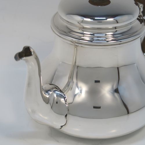 A very handsome Sterling Silver Bachelor size teapot, in a George I style with a plain round bellied body, having a hinged domed lid with wooden finial, a wooden insulated handle, a curved spout, and all sitting on a flat base. This elegant silver teapot was made by Charles Stuart Harris of London in 1923. The dimensions of this fine hand-made silver Bachelor teapot are height 14 cms (5.5 inches), length 21 cms (8.25 inches), and it weighs approx. 445g (14 troy ounces).