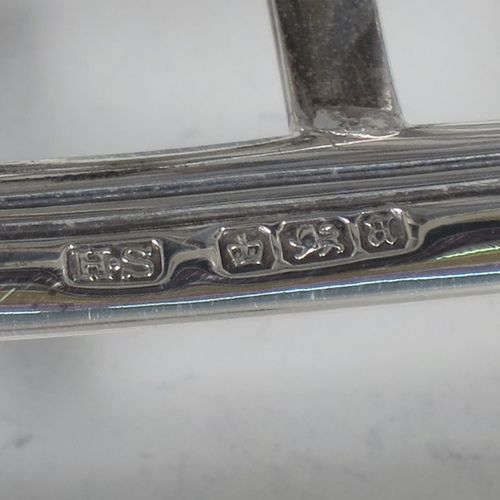 A very unusual Arts and Crafts style Antique Victorian Sterling Silver seven-bar toast-rack, in a very angular style inspired by a Christopher Dresser design, attached to a rectangular base with a reeded border and a strengthening strut, and sitting on four cast foliate and scroll feet. Made by Henry Stratford (who had links with Christopher Dresser) of Sheffield in 1893. The dimensions of this fine hand-made antique silver toast-rack are length 16 cms (6.25 inches), height 14 cms (5.5 inches), width 10 cms (4 inches), and it weighs approx. 348g (11.2 troy ounces).
