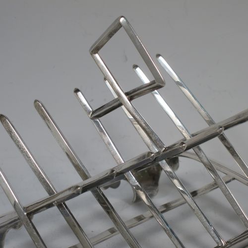 A very unusual Arts and Crafts style Antique Victorian Sterling Silver seven-bar toast-rack, in a very angular style inspired by a Christopher Dresser design, attached to a rectangular base with a reeded border and a strengthening strut, and sitting on four cast foliate and scroll feet. Made by Henry Stratford (who had links with Christopher Dresser) of Sheffield in 1893. The dimensions of this fine hand-made antique silver toast-rack are length 16 cms (6.25 inches), height 14 cms (5.5 inches), width 10 cms (4 inches), and it weighs approx. 348g (11.2 troy ounces).