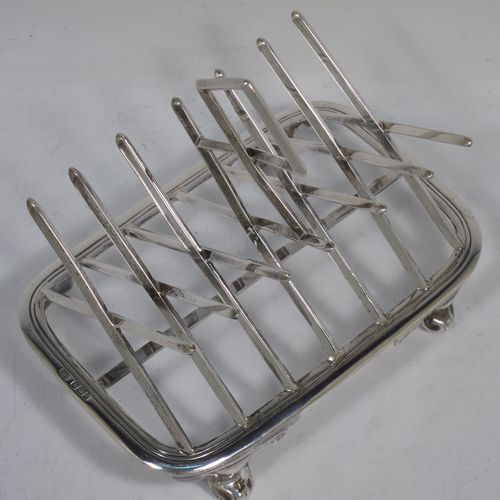 A very unusual Arts and Crafts style Antique Victorian Sterling Silver seven-bar toast-rack, in a very angular style inspired by a Christopher Dresser design, attached to a rectangular base with a reeded border and a strengthening strut, and sitting on four cast foliate and scroll feet. Made by Henry Stratford (who had links with Christopher Dresser) of Sheffield in 1893. The dimensions of this fine hand-made antique silver toast-rack are length 16 cms (6.25 inches), height 14 cms (5.5 inches), width 10 cms (4 inches), and it weighs approx. 348g (11.2 troy ounces).